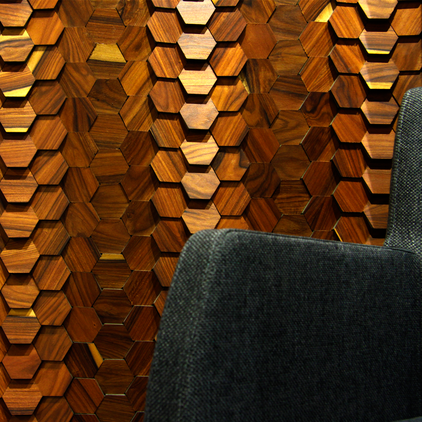 PL.WA-D01 A PL.IW-D01 environment, with a lounge chair on the front, The panel is retroilluminated by an orange light, which further enhances the contrast between pieces.