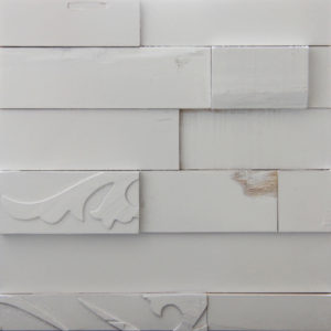 A white painted wood pattern with horizontal strips. Each strip is different than the other, either in size or the pattern on top.