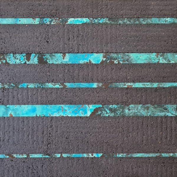 This design is a mix between metal strips and cork strips, each applied in a horizontal layout. The metal panel is a oxidised zinc panel, with a blue tonality. The cork is expanded black cork, with a flat surface.